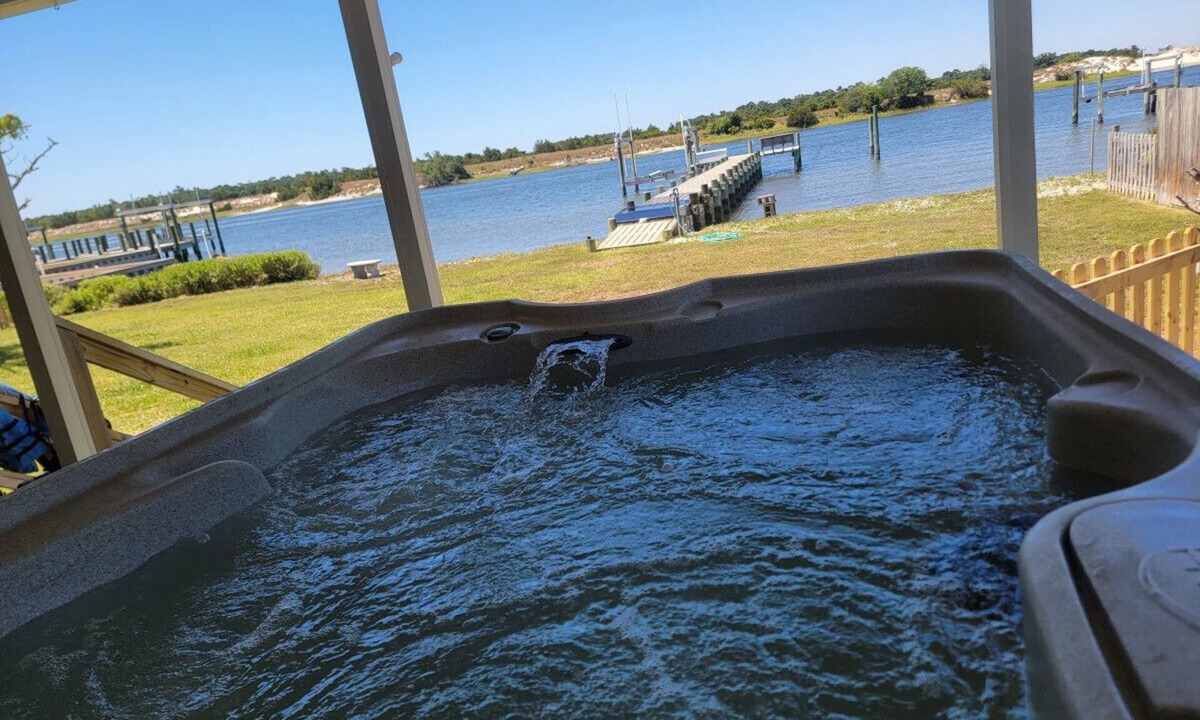 Cedar Point Apartment | Waterfront with private dock, Hot tub, & swim mat. Large fenced backyard and screened in porch for relaxing.