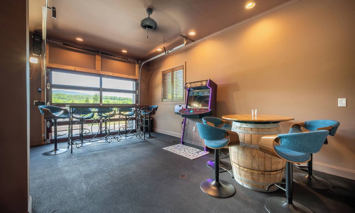 Ironto House | Welcome to this spectacular home, which stands out for its soaring stone fireplace, a bright sunroom, and a unique indoor-outdoor entertainment lounge with a classic arcade game!