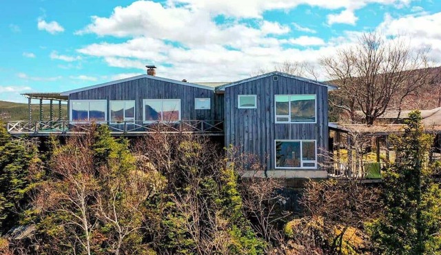 Enjoy the stunning views of the Cape Breton Highlands atop this cliffside estate